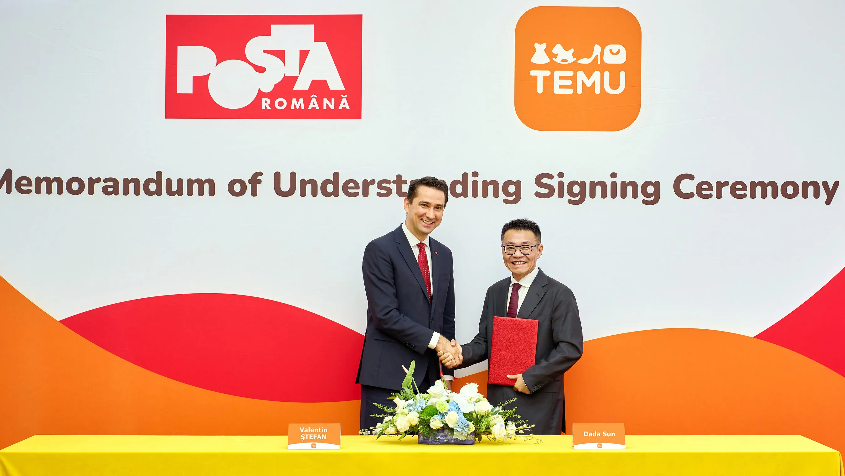 Two suited men shake hands at a TEMU and Poșta Română memorandum signing ceremony.