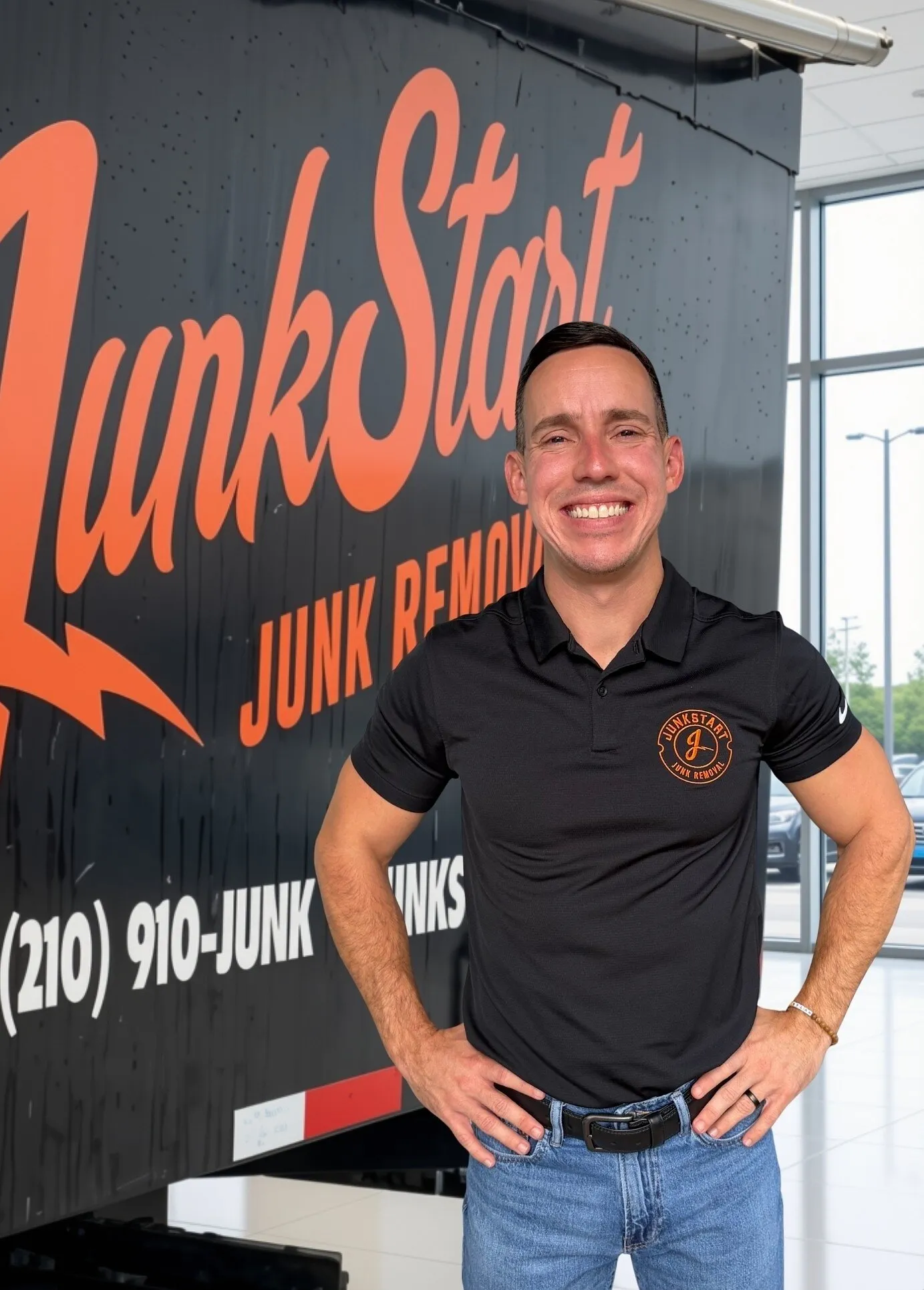 Bryan Cross stands beside a JunkStart junk removal truck.