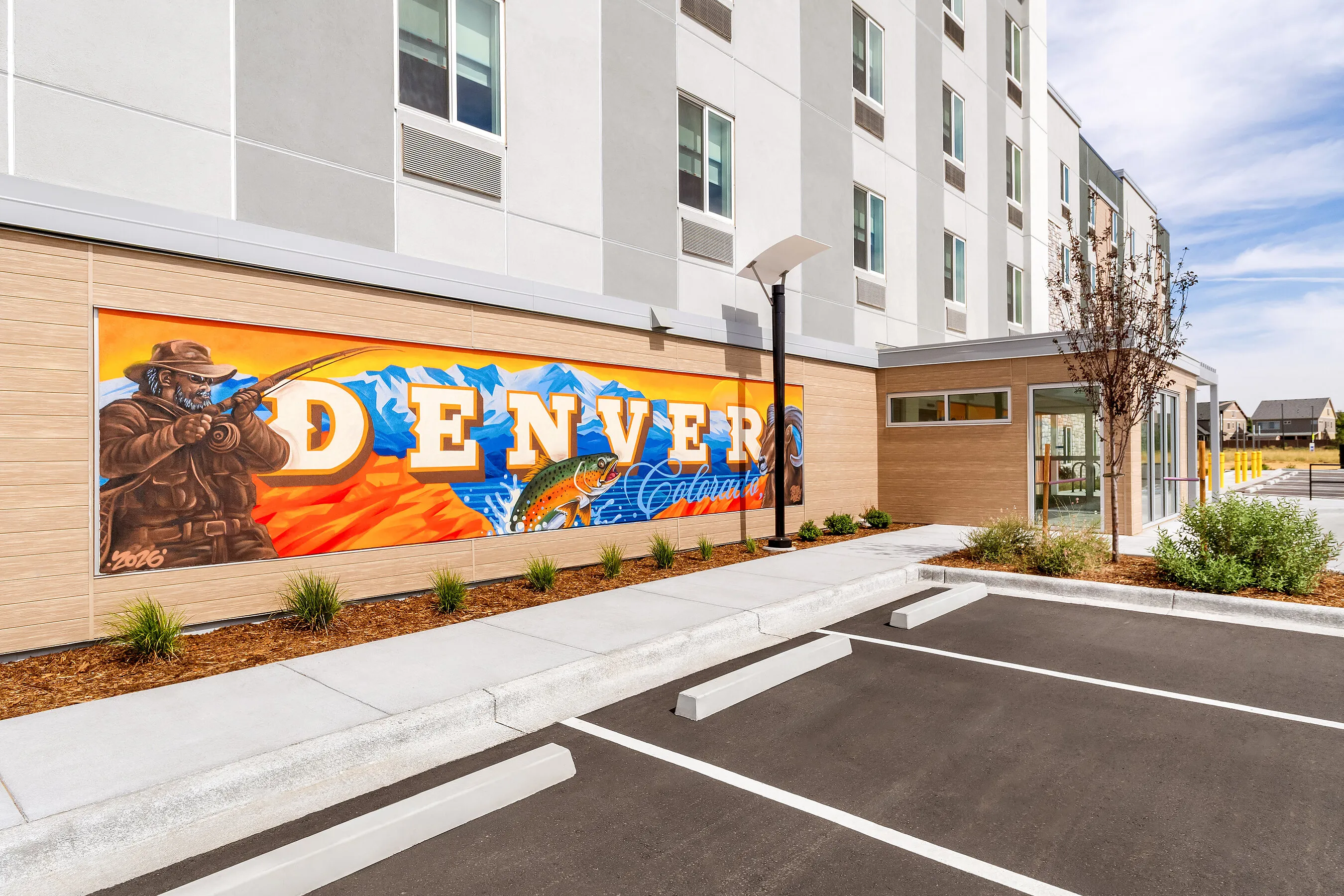 Everhome Denver mural with a cowboy, mountains and trout beside a building entrance