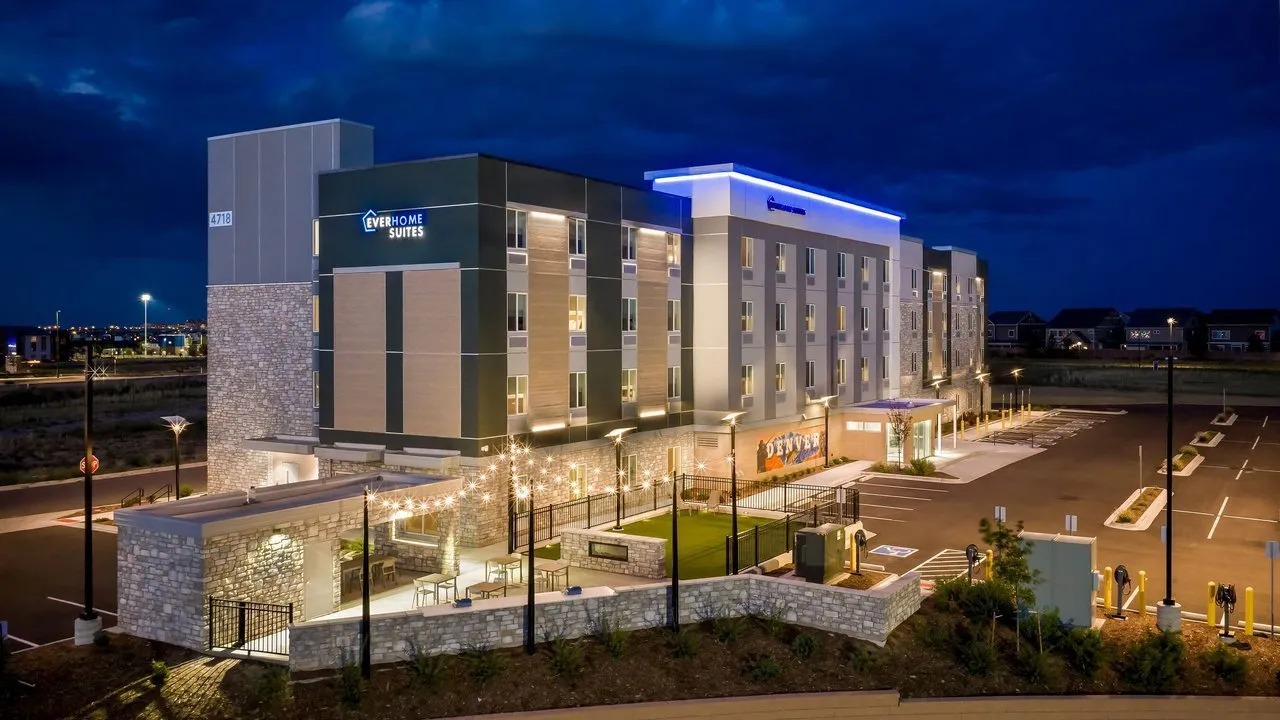 Everhome Suites hotel exterior at night with illuminated entrance and parking lot.