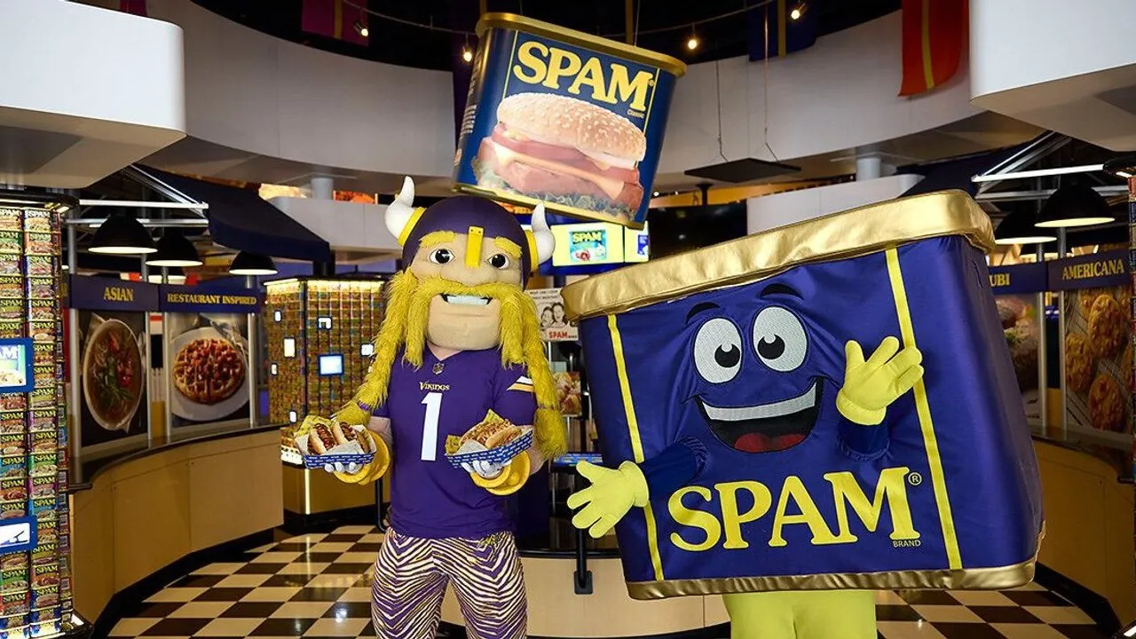 Viktor mascot holding hot dogs beside a SPAM can mascot in a SPAM store
