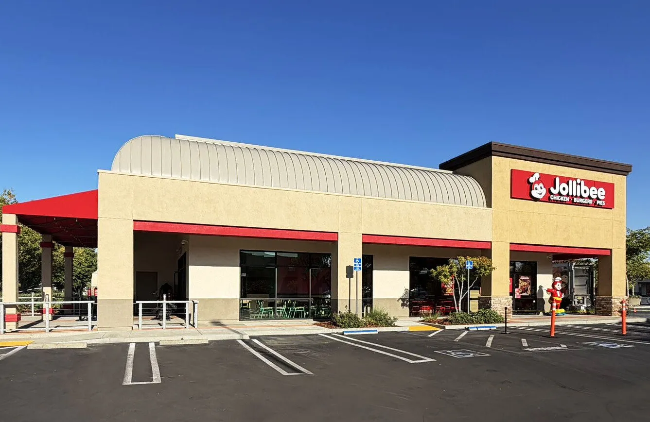 A Jollibee restaurant exterior with parking spaces in front.