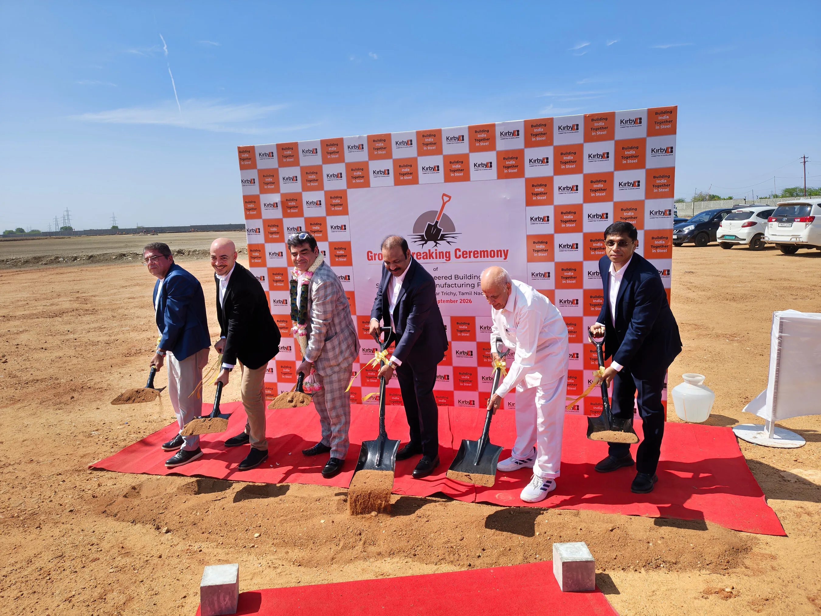 Six men dig with ceremonial shovels at a Kirby building groundbreaking event.