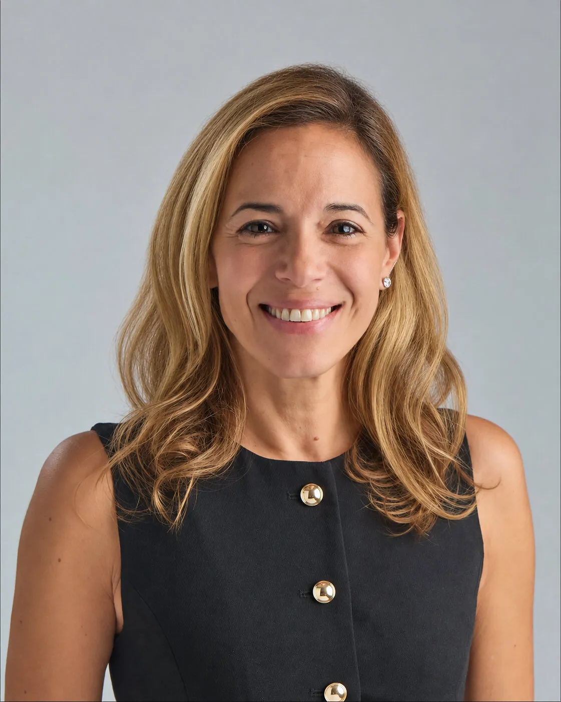 Lark Marie Antón smiling against a light grey background.