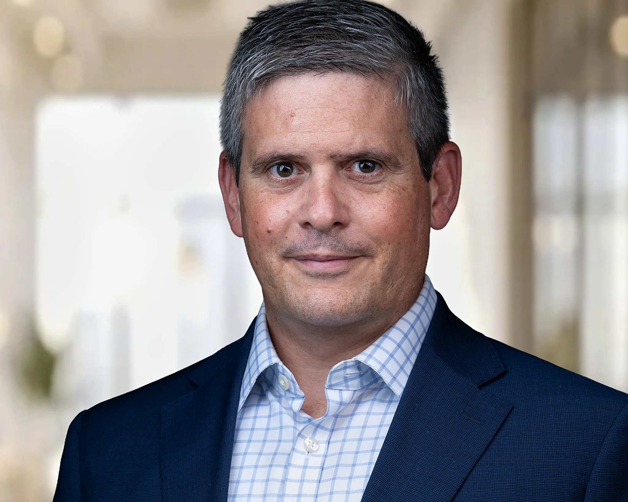 Benjamin Sigel in a blue suit jacket and checkered shirt.