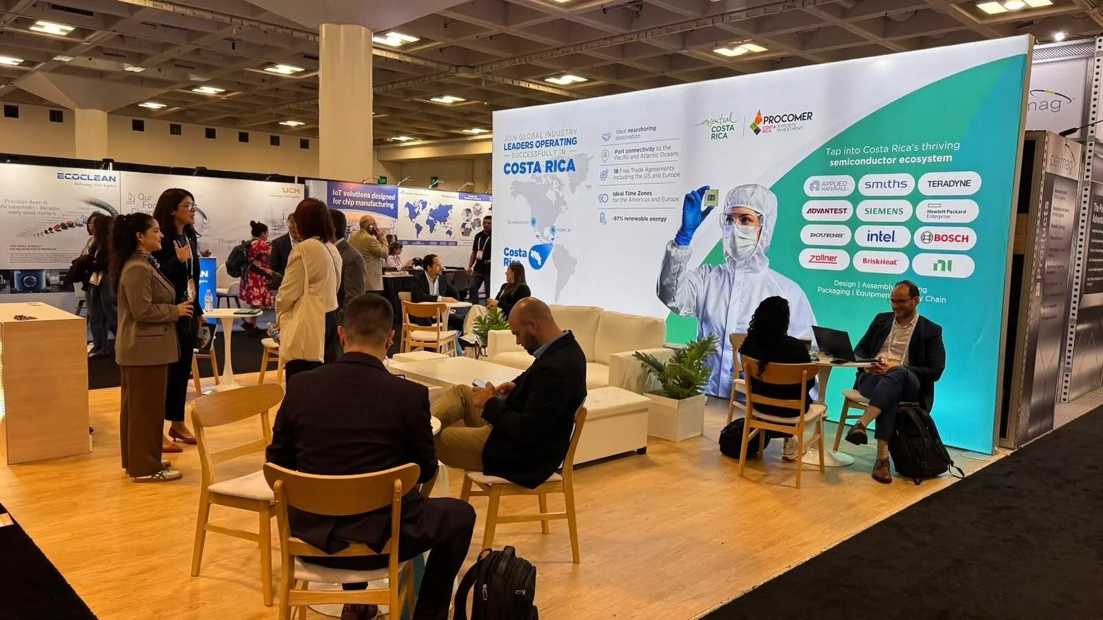 Trade-show booth with Costa Rica manufacturing display, chairs, tables, and attendees.