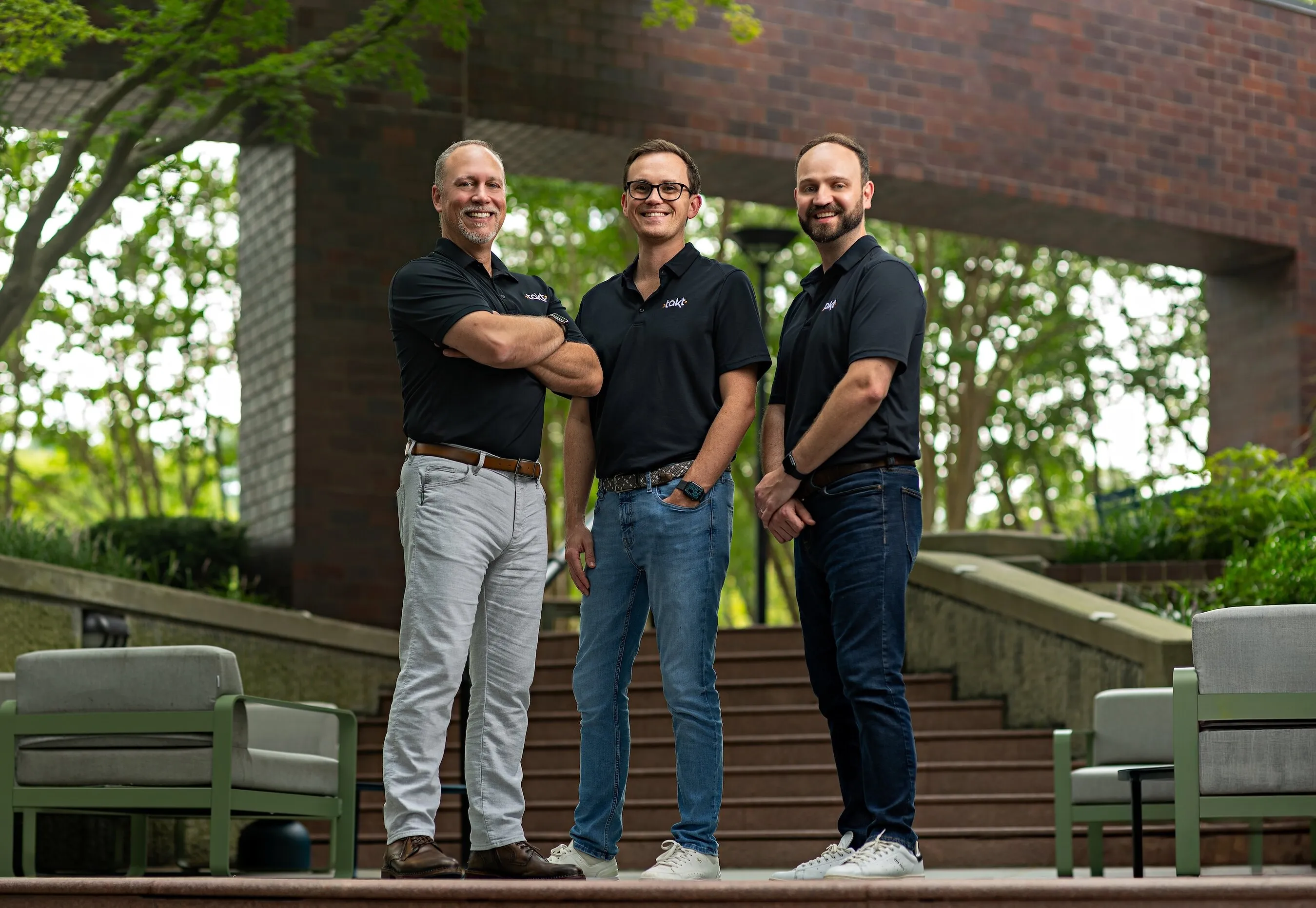 Three Takt co-founders standing outdoors in black polo shirts