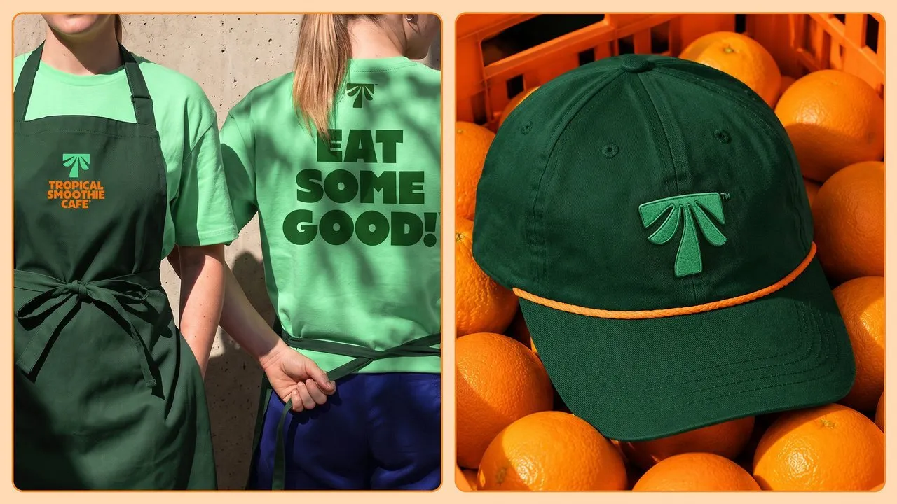 Two staff in Tropical Smoothie Cafe aprons and T-shirts, beside a green Palm T cap resting on oranges
