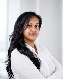 Lakshmi Rampersaud in a white shirt with arms crossed.