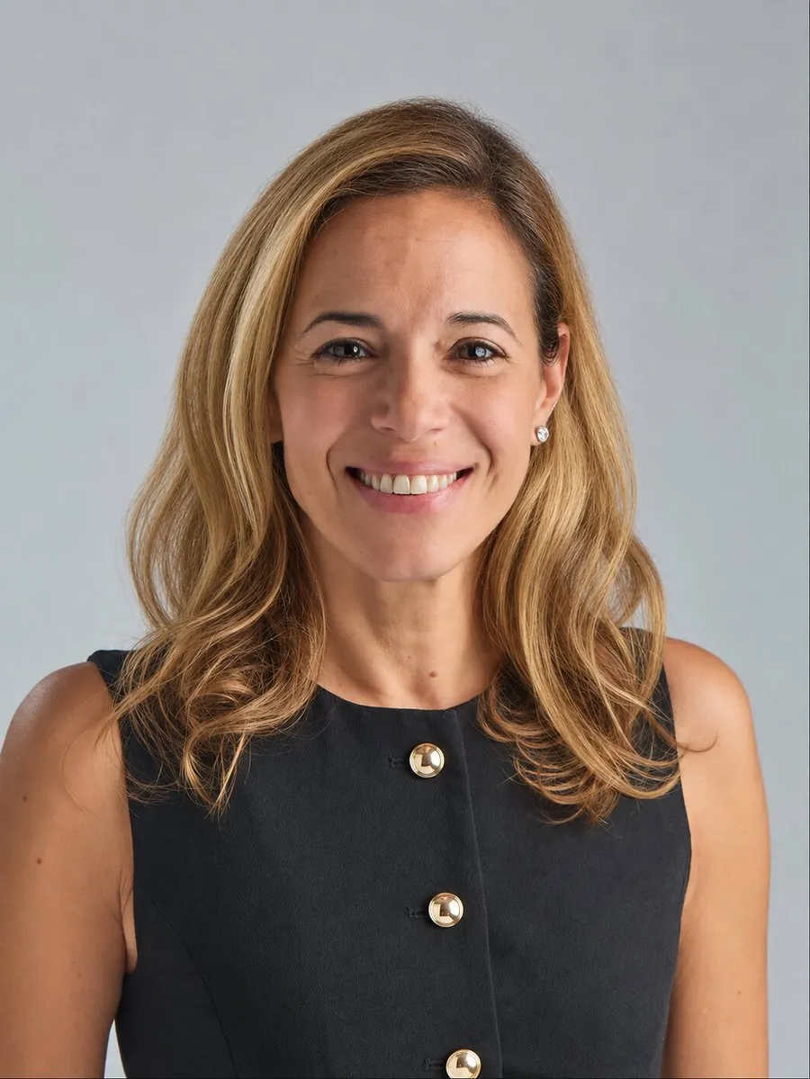 Lark Marie Antón smiling against a light grey background.